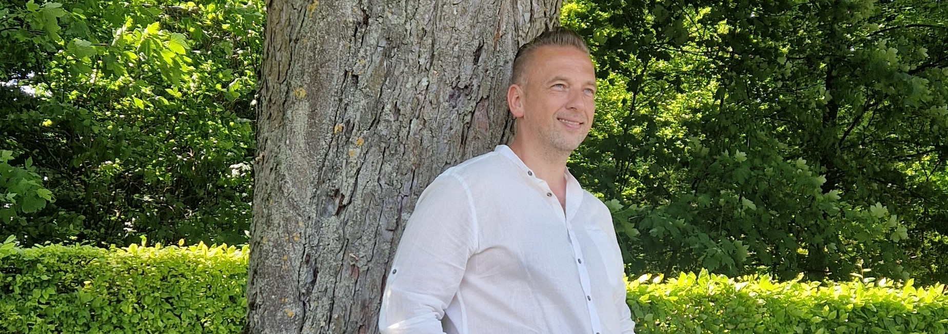 Tomek coach oparty o drzewo